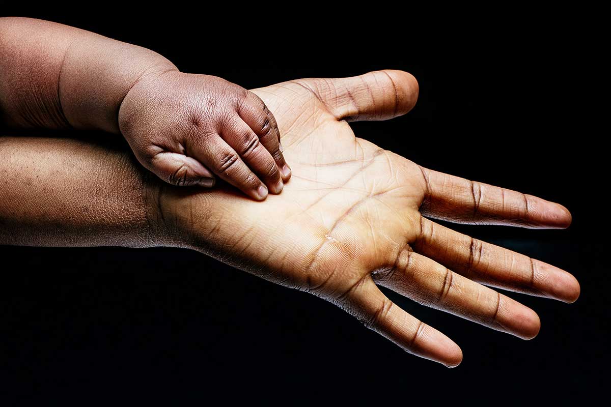 Eine Kinderhand liegt in der Hand einer erwachsenen Person